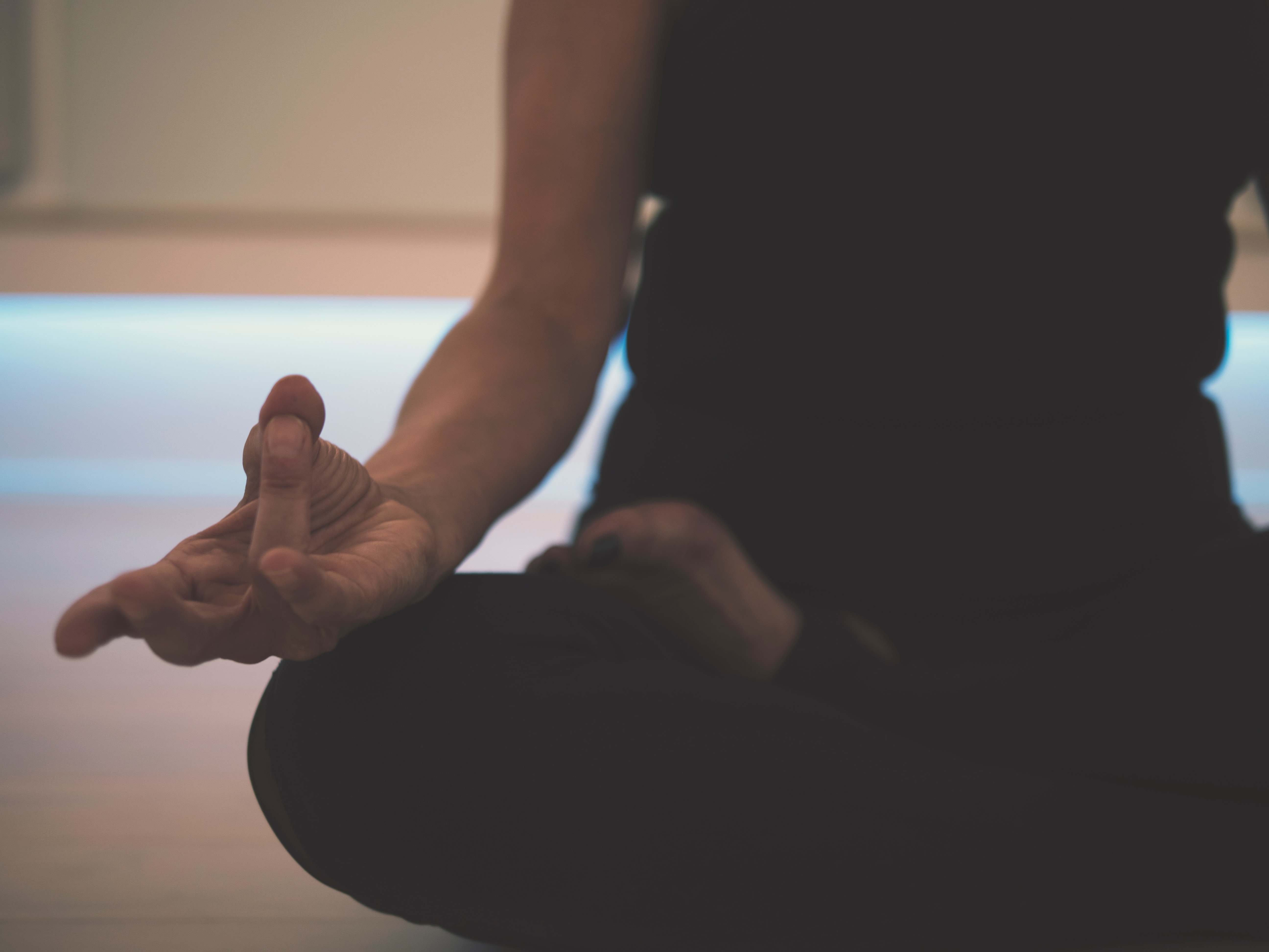 focus sur un corp de femme en position de yoga lotus