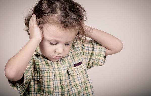 Jeune enfant autiste se mettant les mains sur les oreilles