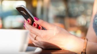 Plan sur des mains consultant un smartphone à la table d'un café