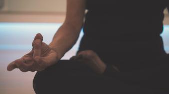 focus sur un corp de femme en position de yoga lotus