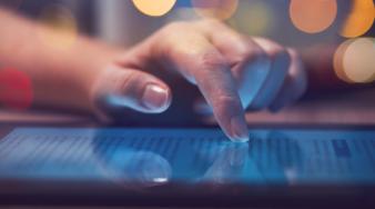 doigts d'une main qui consultent une tablette informatique
